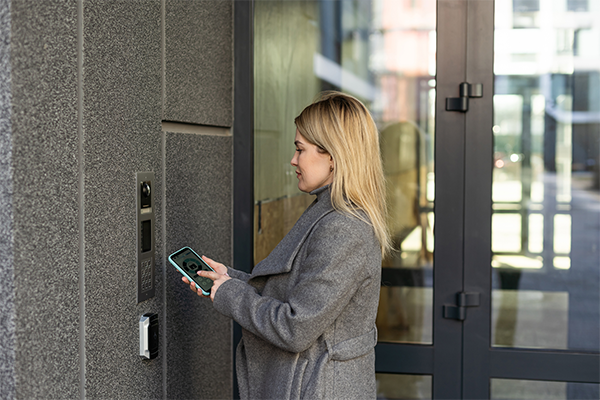 Woman using her phone to unlock a door